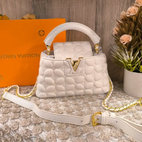 Louis Vuitton Quilted Vanity Bag (Cannes style), White soft leather with circular quilting, rigid top handle, bold gold-tone V logo, and gold chain crossbody strap.