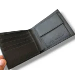 محفظة رجالية أرماني إكسشينج AX، محفظة بفتحتين باللون الأسود بنقشة سافيانو، لوجو A|X بارز في المنتصف، مع صندوق هدايا رسمي.