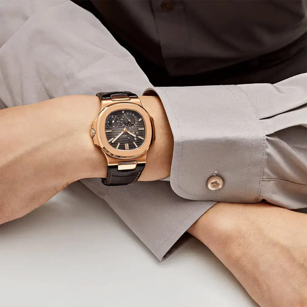 Patek Philippe Nautilus: 5712R-001 18K rose gold watch with moon phase, black-brown dial, and brown alligator leather strap.