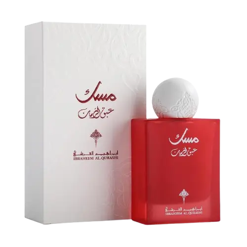 لقطة مذهلة توضح زجاجة عطر مسك عبق الرمان الأيقونية بحجم 75 مل بجانب علبة التغليف البيضاء الفاخرة الـ أسطورية ذات النقوش التقليدية."